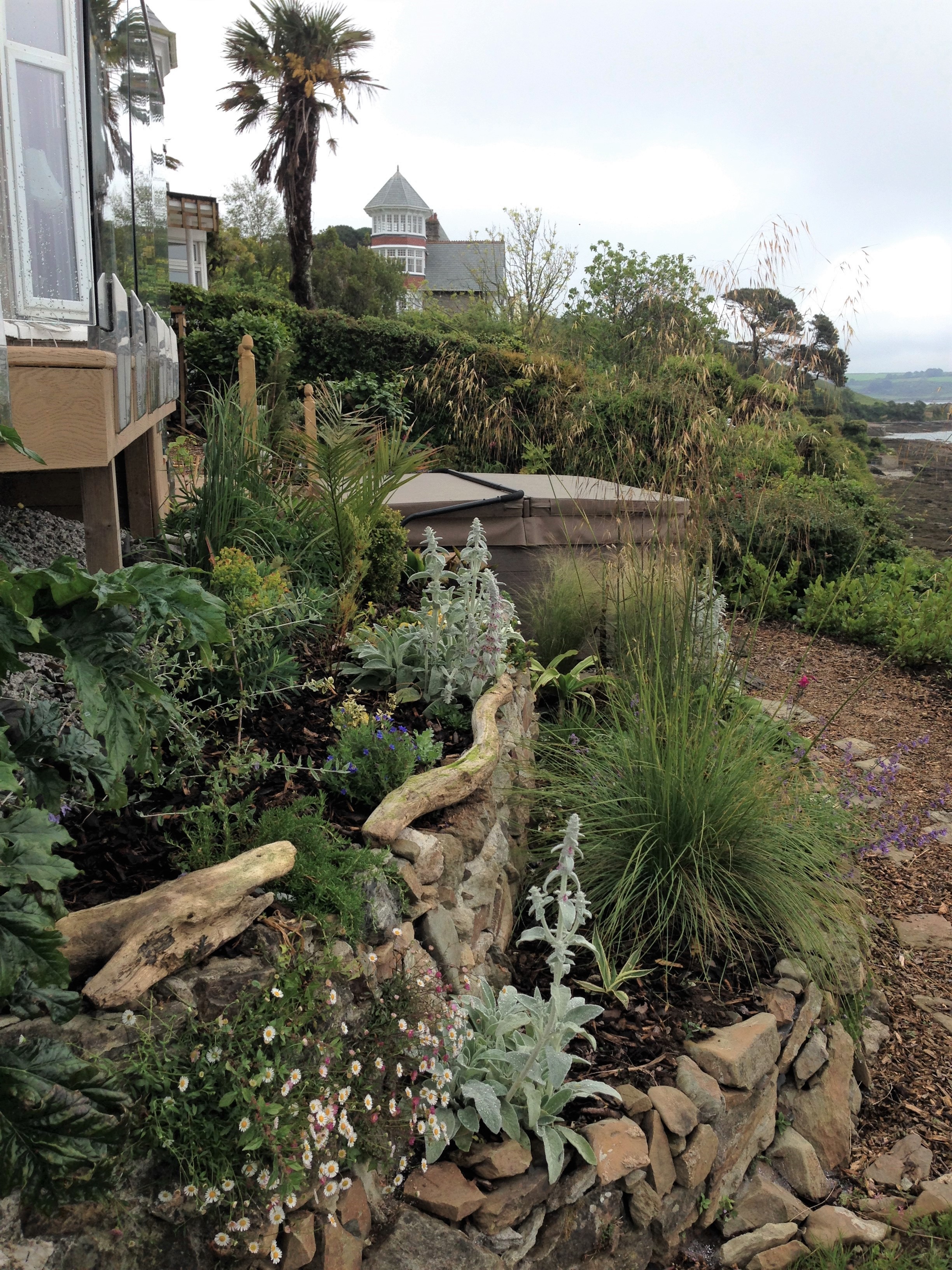 view of hot tub set within landscaped retaining walls enjoying views out to sea